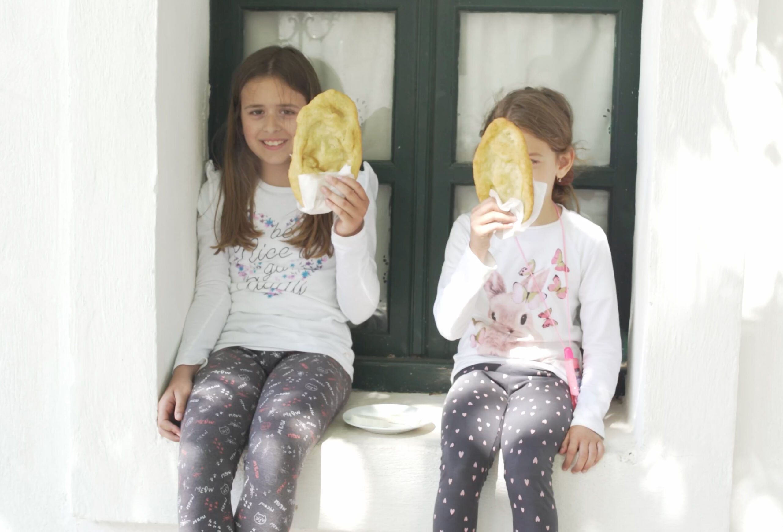 Two young girls holding pita bread.